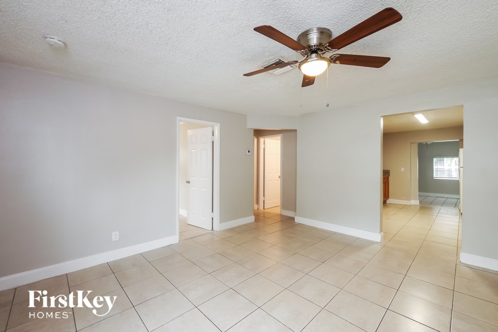 A spacious room with a ceiling fan and tile flooring.