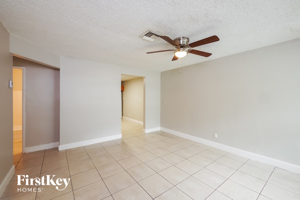 A room with a ceiling fan and tiled floor.