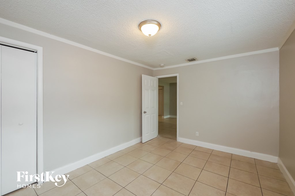A room with a white door and a tiled floor.