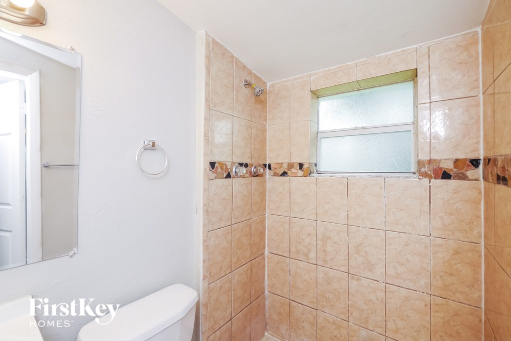 A bathroom with a tiled shower and a toilet.