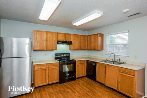 A kitchen with wooden cabinets and a stainless steel refrigerator.