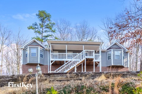 a blue house with a white porch and stairs