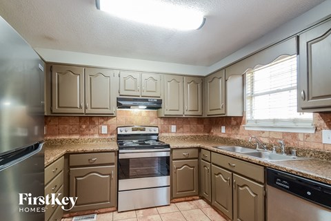 a kitchen with white cabinets and granite counter tops