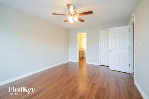an empty living room with wood flooring and a ceiling fan