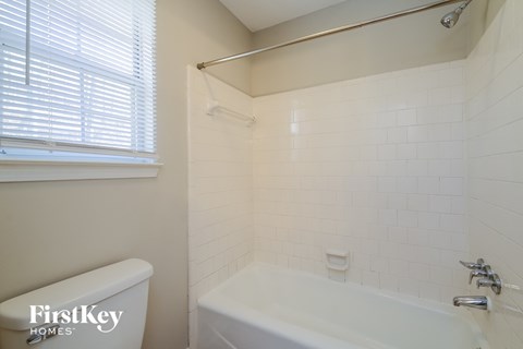 a bathroom with a tub and a sink and a window