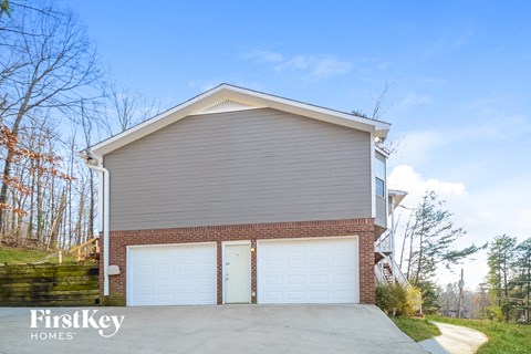 a garage with a white garage door and a brick house