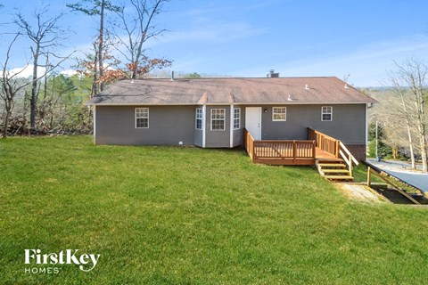 a house with a deck and a yard and a pool