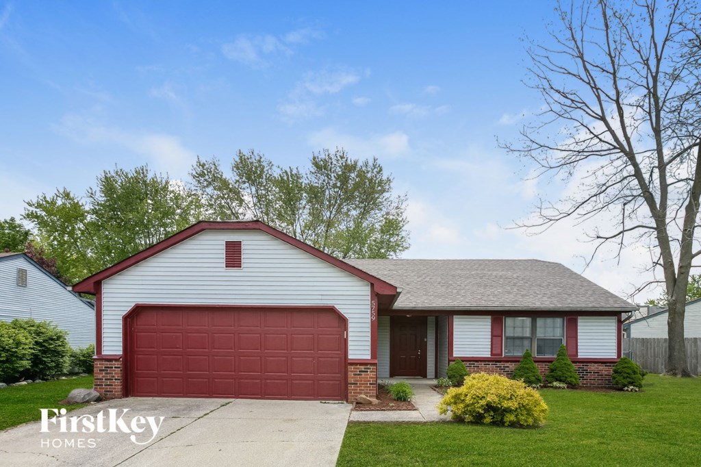 a red garage door in front of a white house