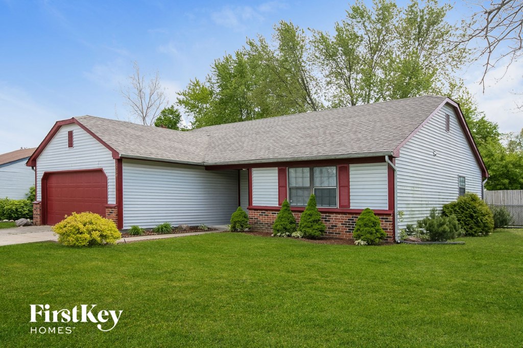 front view of a white house with a red garage door