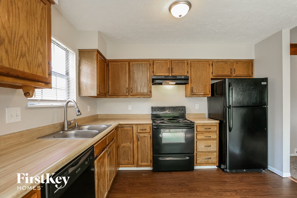 a kitchen with black appliances and wooden cabinets