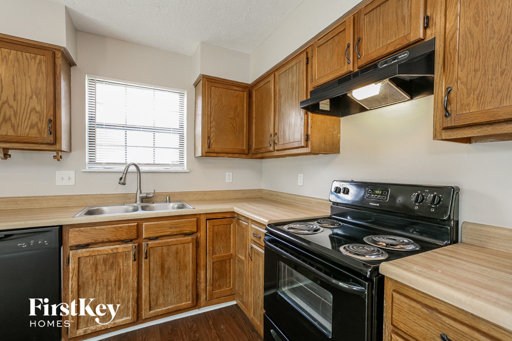 a kitchen with black appliances and wooden cabinets