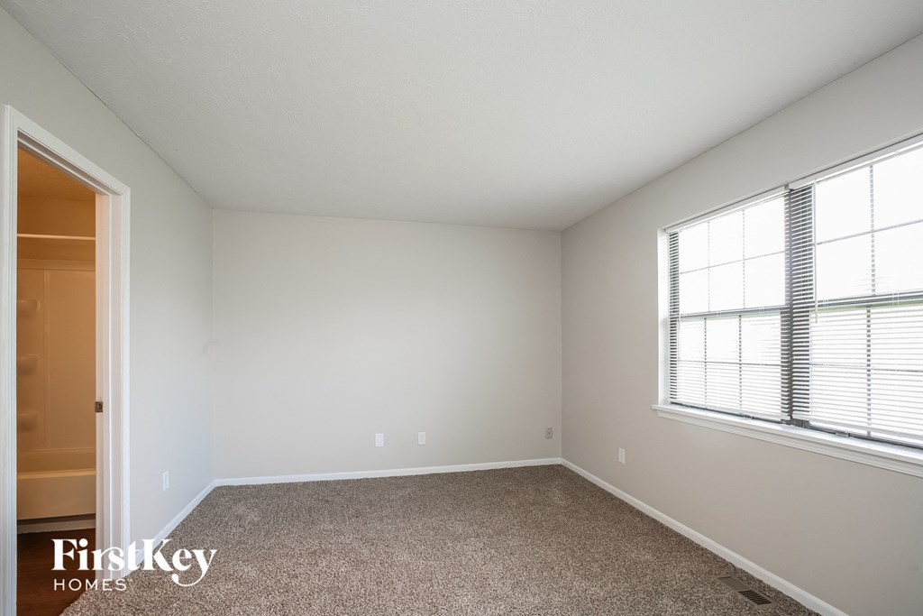 a bedroom with a carpeted floor and two windows