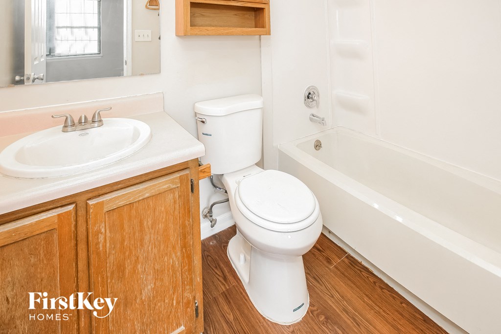 a bathroom with a toilet and a sink and a bath tub