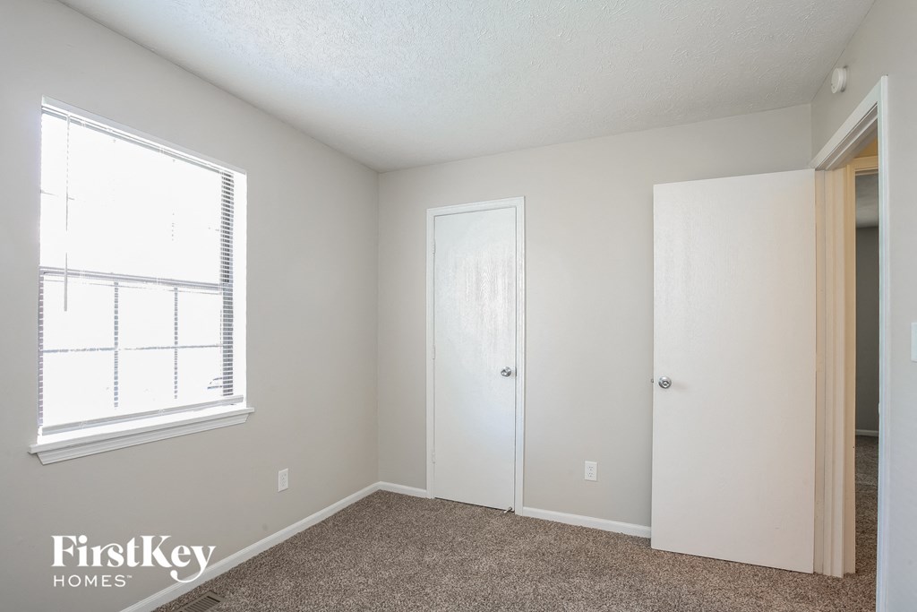 a bedroom with a closet and a window and a door