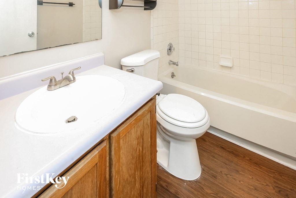 a bathroom with a toilet and a sink and a bath tub