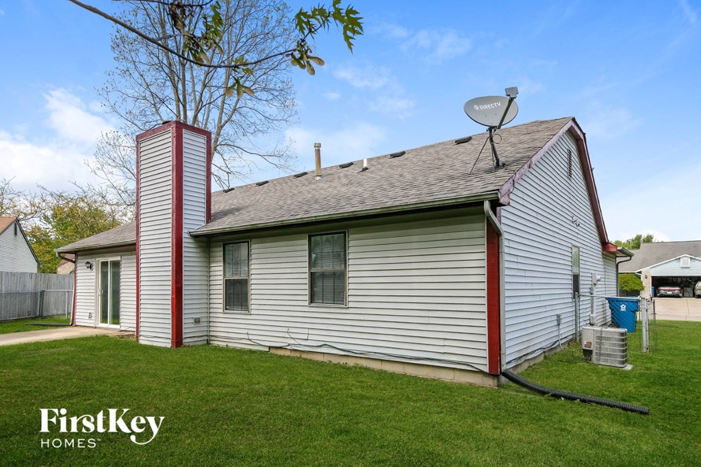 a small white house with a satellite dish on the roof