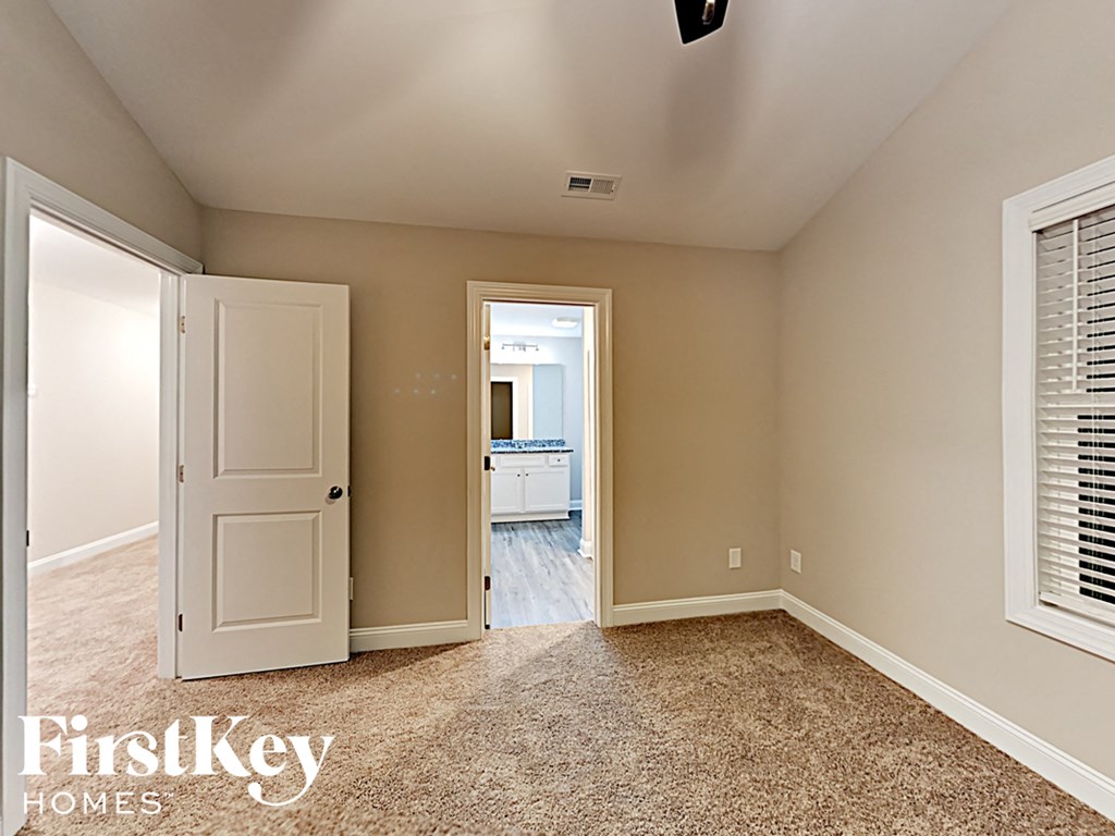 A room with a carpeted floor and a doorway leading to another room.