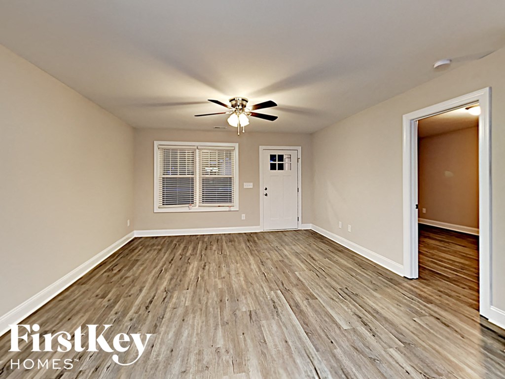 A room with wooden flooring and a ceiling fan.
