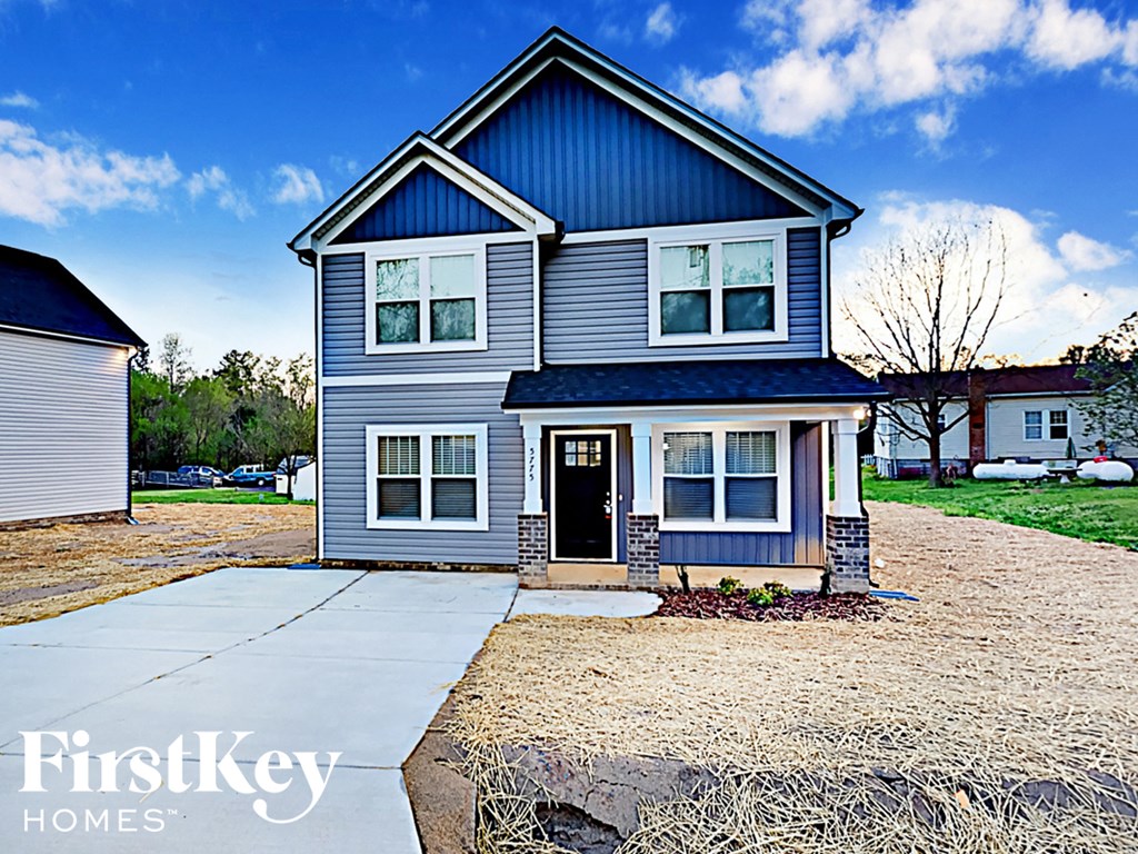 A blue house with a white door and windows is for sale.