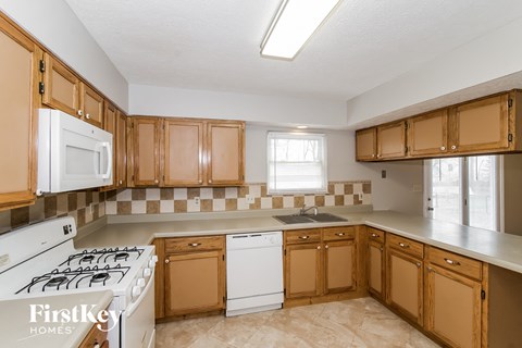 a kitchen with wooden cabinets and a white stove top oven