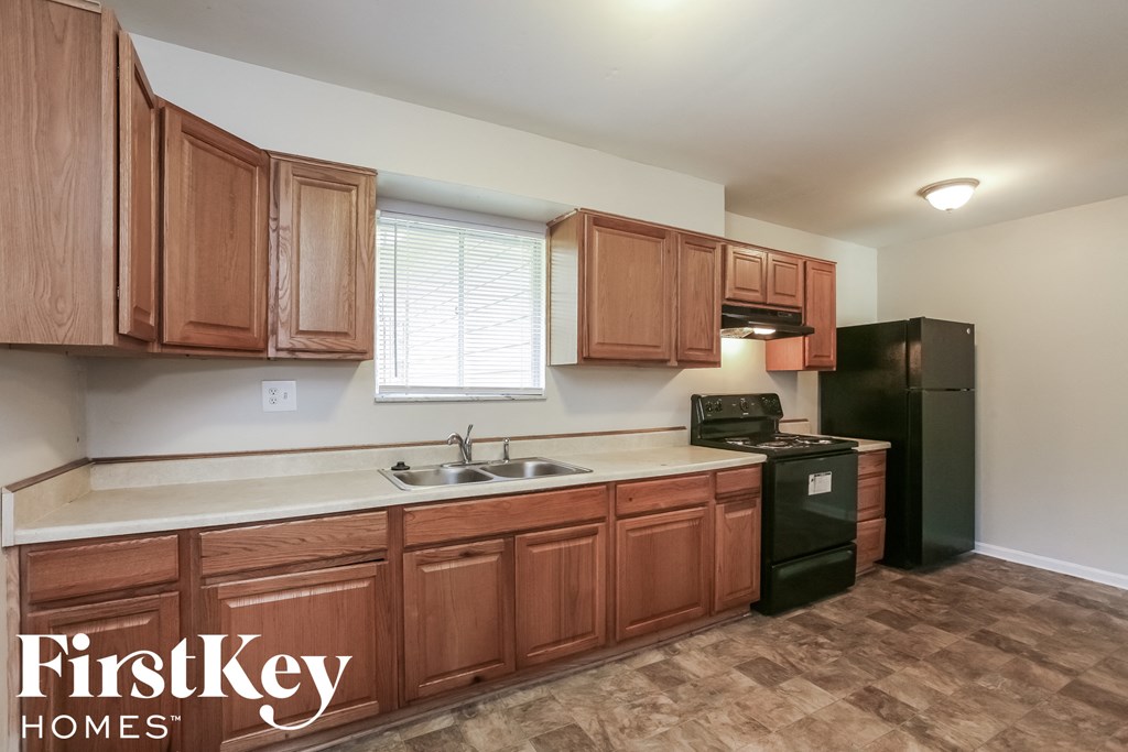a kitchen with wooden cabinets and a sink and a refrigerator