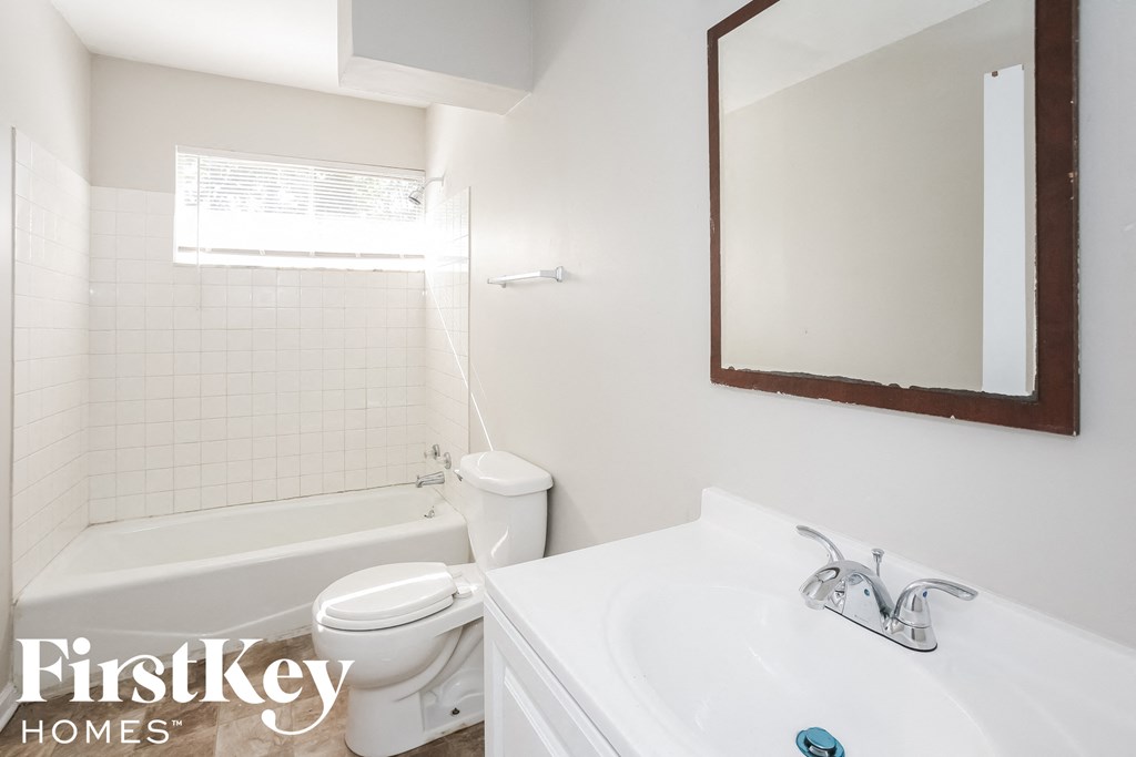 a bathroom with a sink toilet and bath tub and a mirror