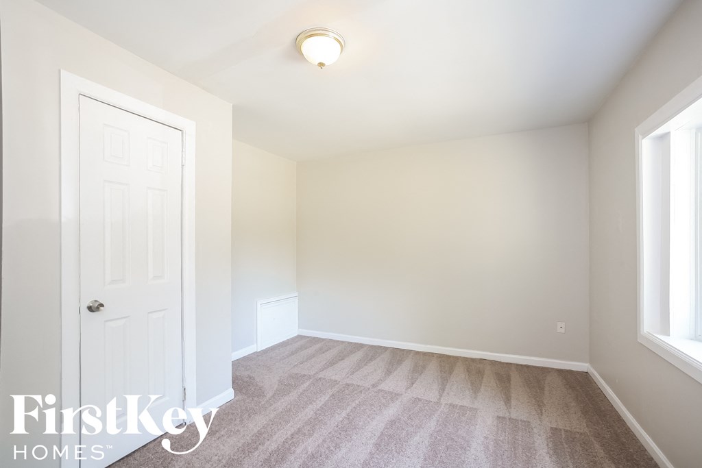 a bedroom with a white door and a carpeted floor