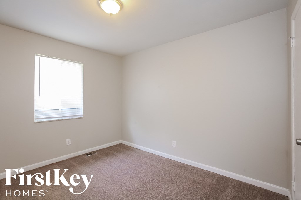 a bedroom with a carpeted floor and a window