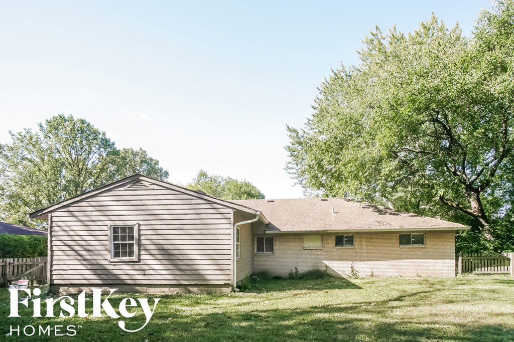 a small house with a yard and a tree
