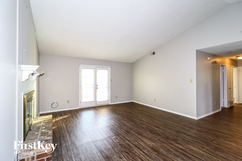 the living room and dining room with wood flooring and a fireplace