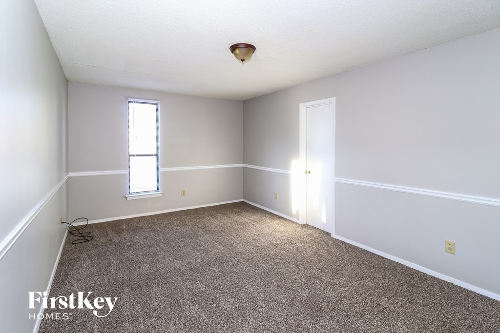 a empty room with white walls and a carpet
