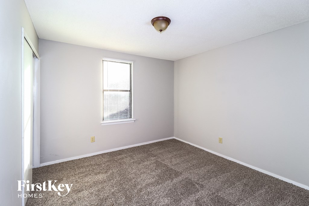 an empty room with carpet and a window