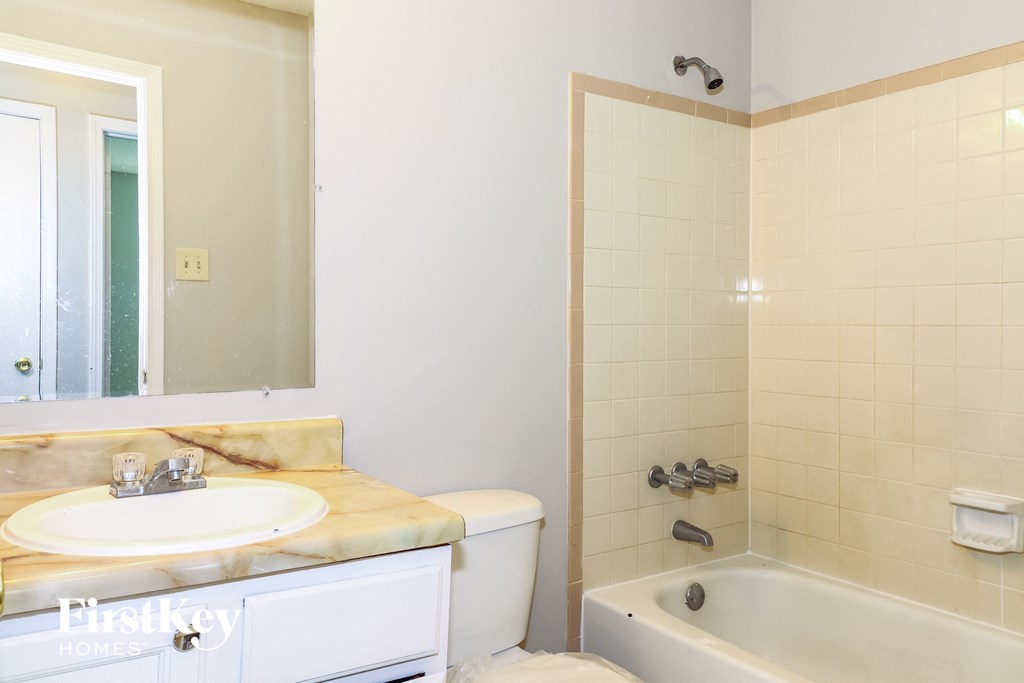 a bathroom with a sink and a bath tub and a mirror