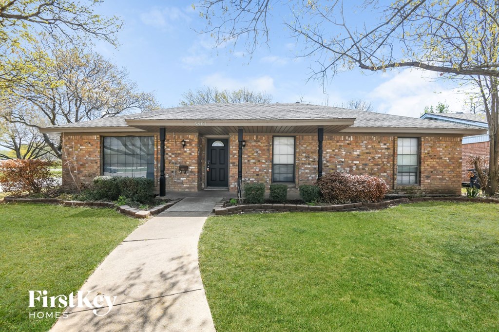 a brick house with a sidewalk in front of it