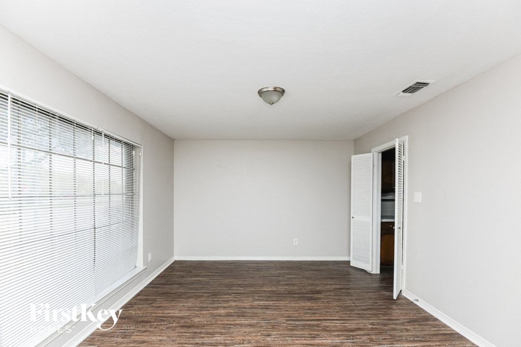 a spacious living room with wood flooring and a large window