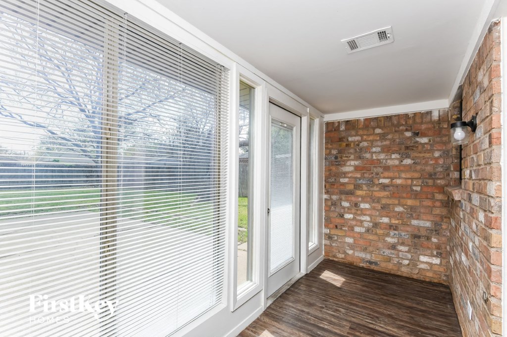 a living room with a brick wall and sliding glass doors