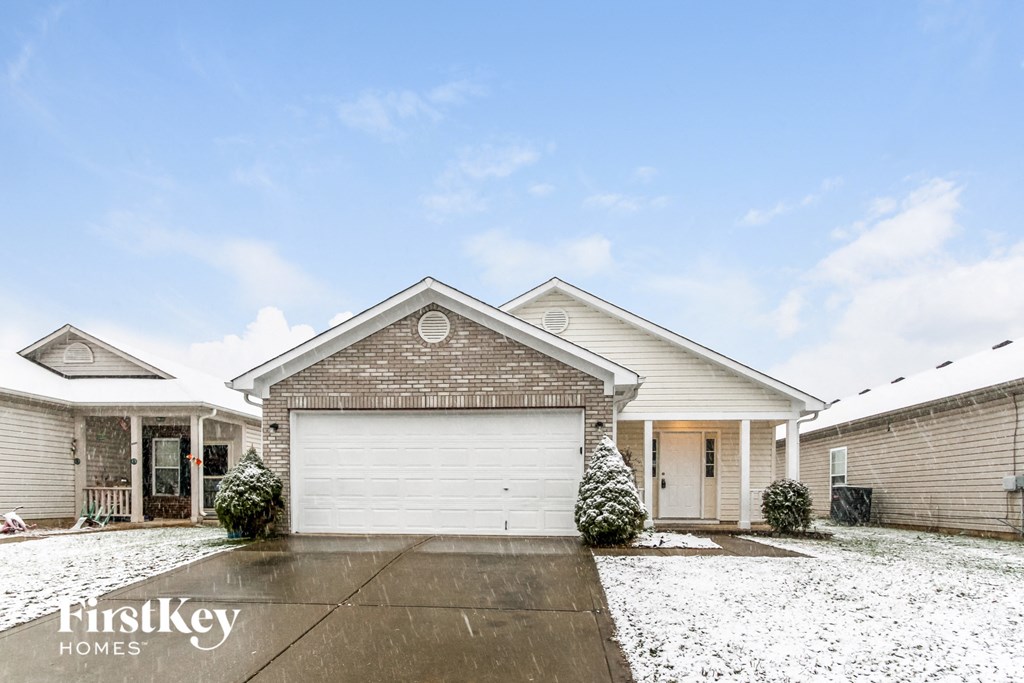 A house with a garage and a driveway in front of it.