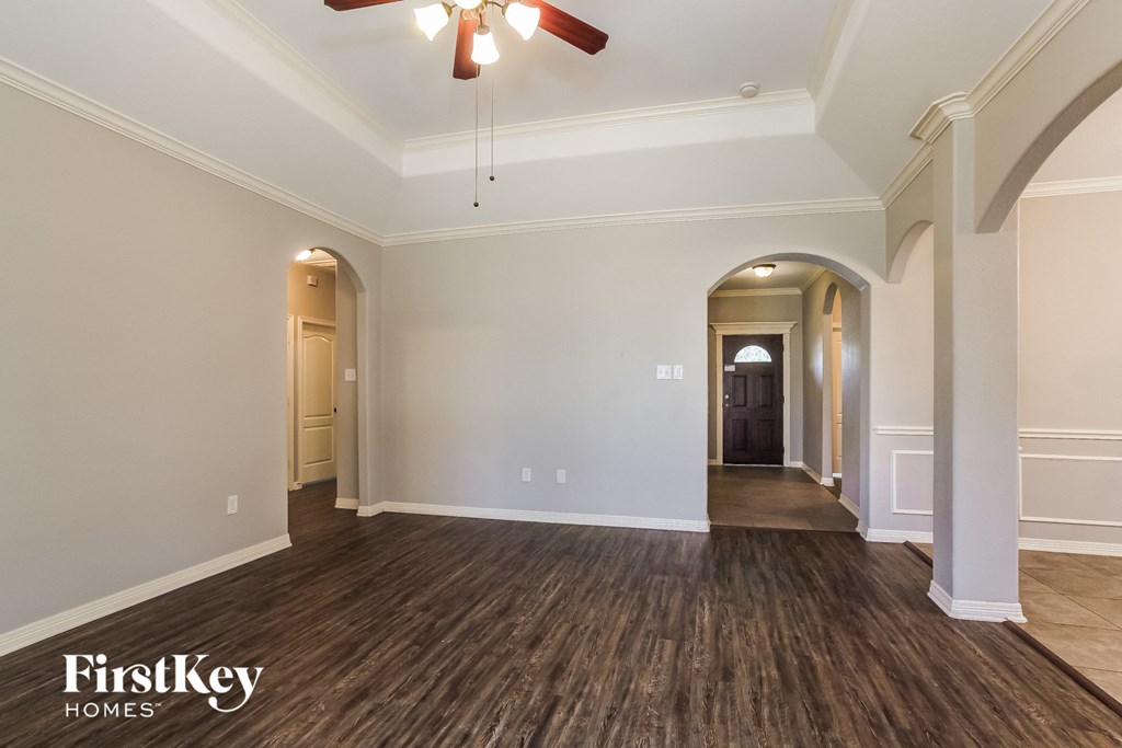 a living room with white walls and a ceiling fan
