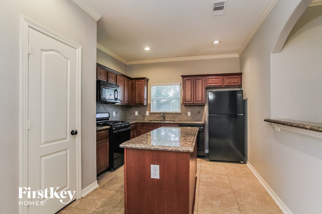 a kitchen with black appliances and a granite counter top