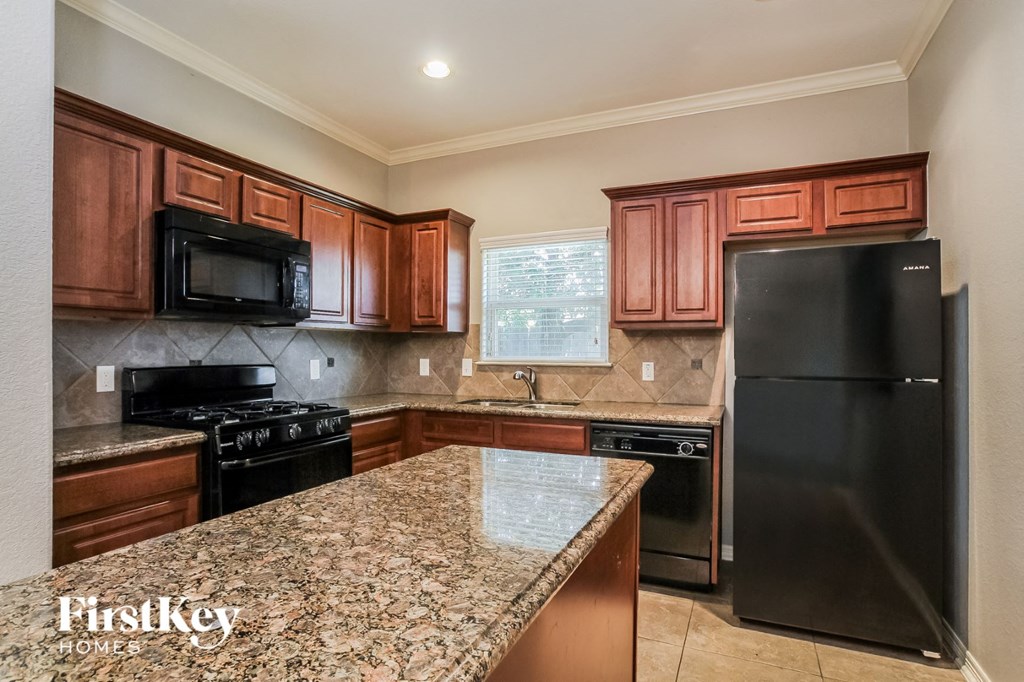 a kitchen with granite counter tops and black appliances