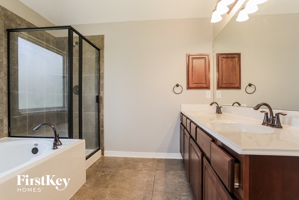 a bathroom with two sinks and a shower and a bath tub