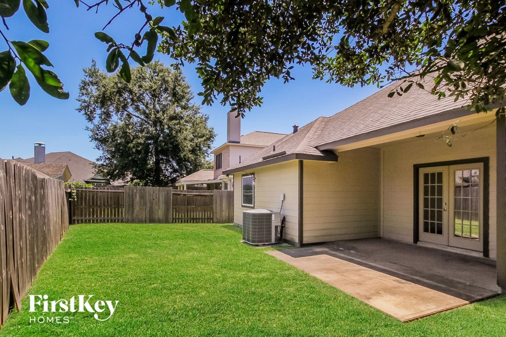 a backyard with a patio and a fence