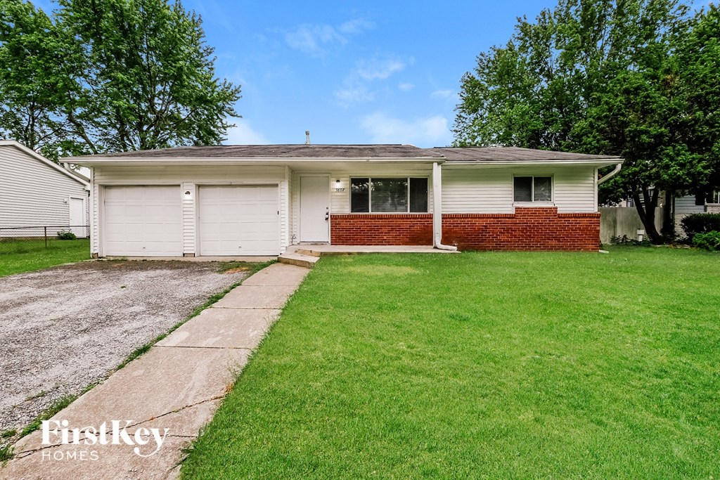 A house with a red brick wall and a white garage door.