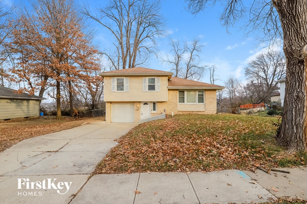 A house with a brown roof and a white garage door is for sale.