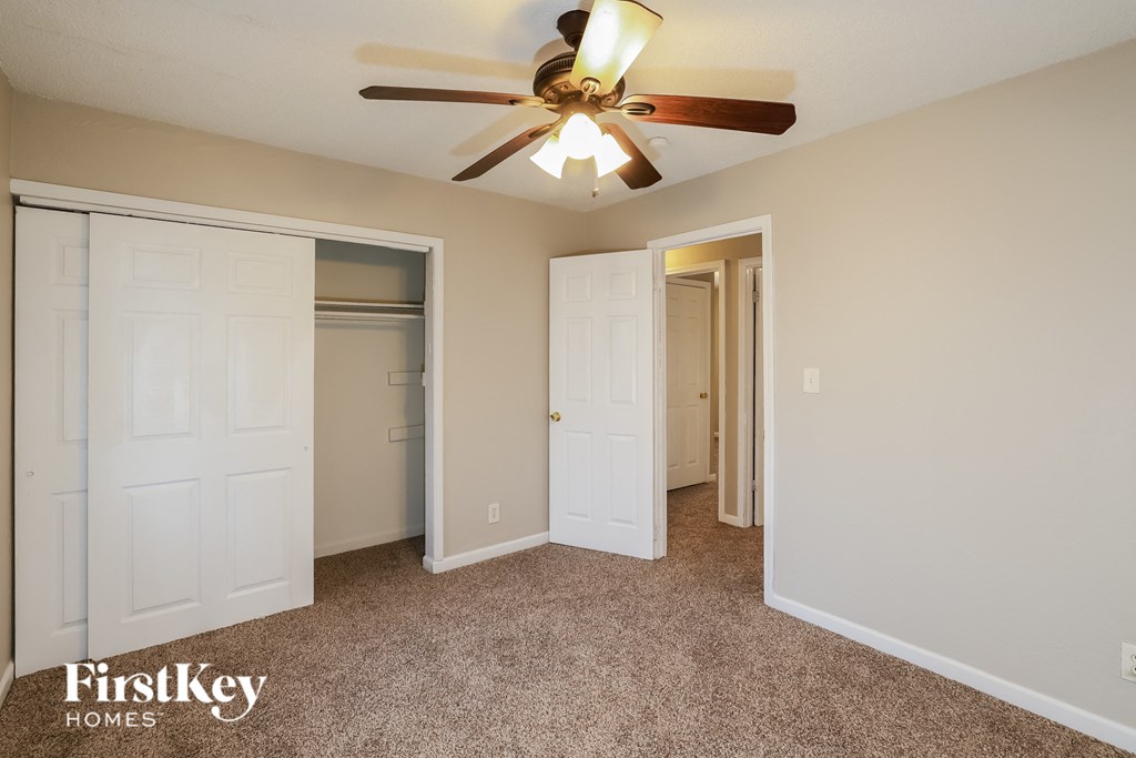 A room with a ceiling fan and two doors.
