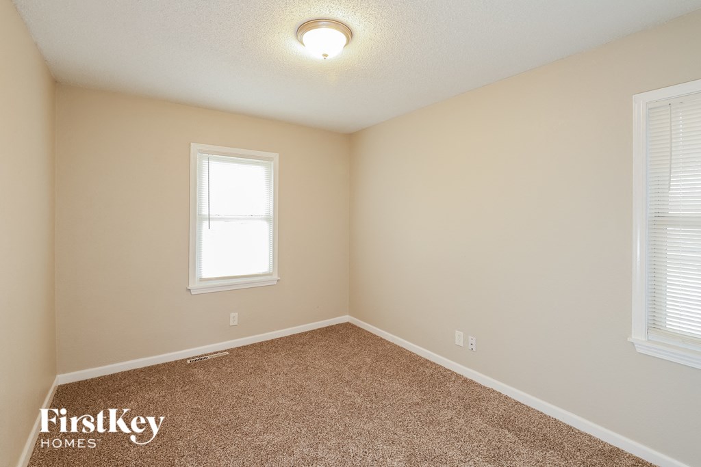 A room with a carpeted floor and a window.