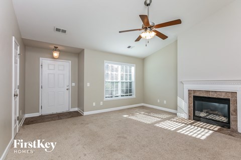 a living room with a fireplace and a ceiling fan