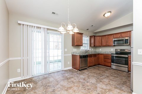 a kitchen with wood cabinets and stainless steel appliances and a large window
