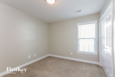 a bedroom with a carpeted floor and a window