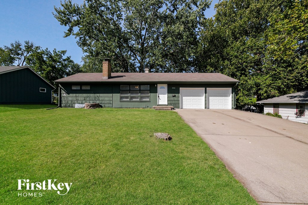 A house with a garage and a driveway in front of it.